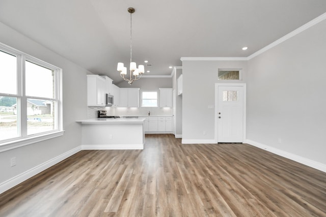 kitchen featuring kitchen peninsula, white cabinetry, a healthy amount of sunlight, and light wood-type flooring