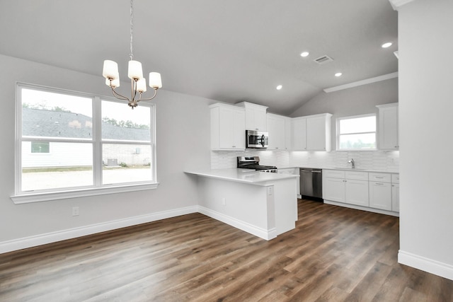 kitchen with kitchen peninsula, white cabinets, dark wood-type flooring, and appliances with stainless steel finishes