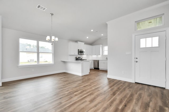 entrance foyer featuring lofted ceiling, crown molding, a chandelier, and dark hardwood / wood-style floors