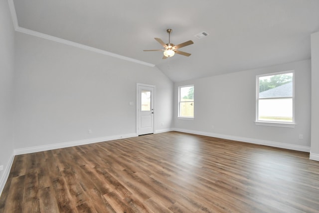 unfurnished room featuring vaulted ceiling, a wealth of natural light, crown molding, and dark hardwood / wood-style floors