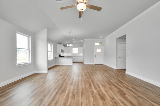 unfurnished living room with light hardwood / wood-style floors, ornamental molding, and a wealth of natural light