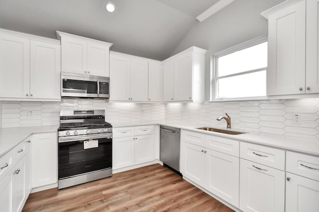 kitchen featuring white cabinets, backsplash, sink, and appliances with stainless steel finishes