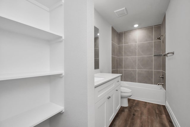 full bathroom featuring vanity, toilet, wood-type flooring, and tiled shower / bath