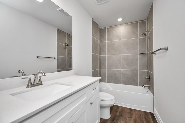 full bathroom with hardwood / wood-style floors, vanity, toilet, and tiled shower / bath