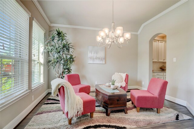 sitting room featuring plenty of natural light, ornamental molding, and a chandelier