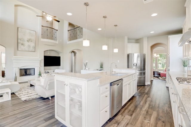 kitchen with a center island with sink, white cabinets, sink, and appliances with stainless steel finishes