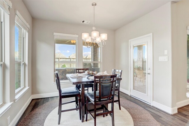 dining room with hardwood / wood-style flooring and a notable chandelier