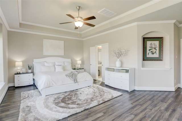 bedroom featuring ensuite bath, ceiling fan, a raised ceiling, dark hardwood / wood-style flooring, and crown molding