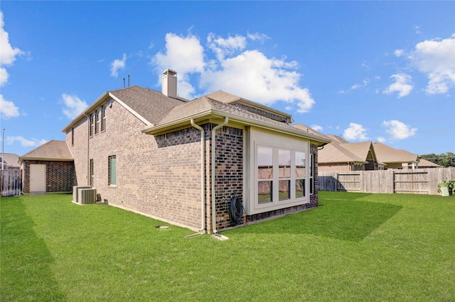 back of house with a yard and central air condition unit