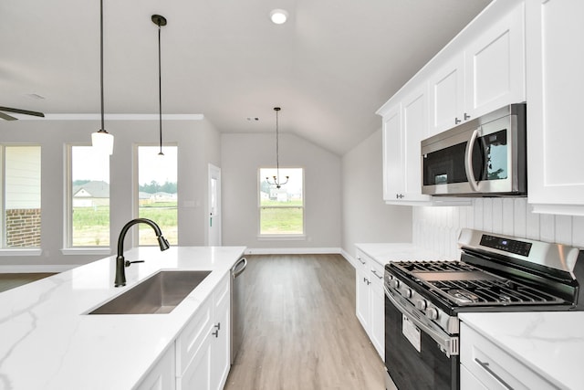 kitchen featuring light stone countertops, sink, white cabinets, and appliances with stainless steel finishes