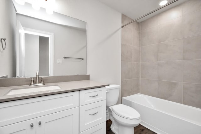 full bathroom featuring hardwood / wood-style floors, vanity, toilet, and tiled shower / bath