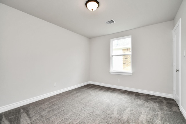 spare room with dark colored carpet