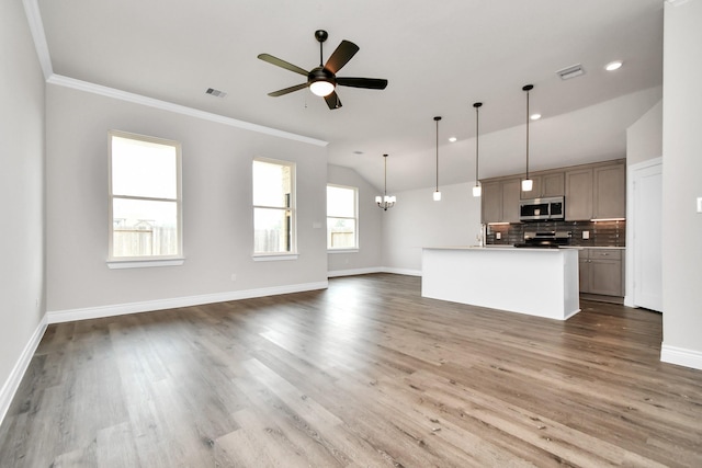 unfurnished living room with ceiling fan with notable chandelier, dark hardwood / wood-style flooring, and crown molding