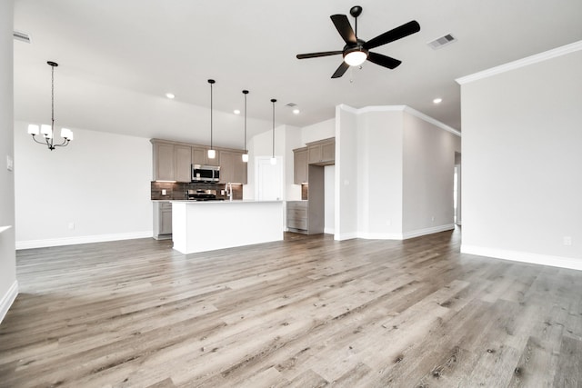 unfurnished living room featuring hardwood / wood-style floors, ceiling fan with notable chandelier, and ornamental molding