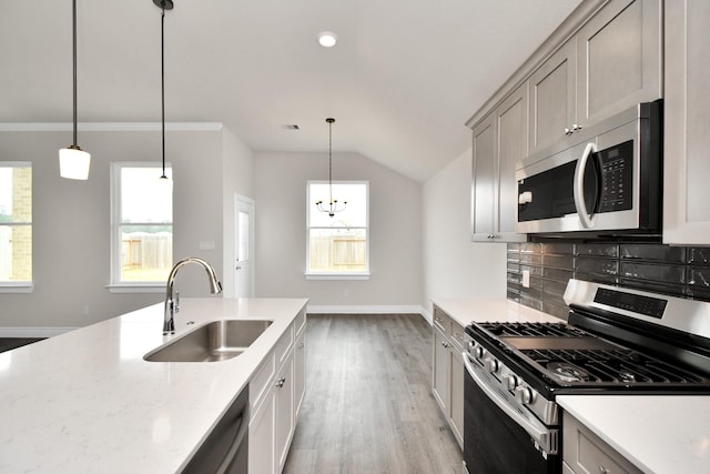 kitchen with backsplash, a healthy amount of sunlight, sink, and appliances with stainless steel finishes