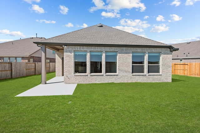 back of house with a lawn and a patio