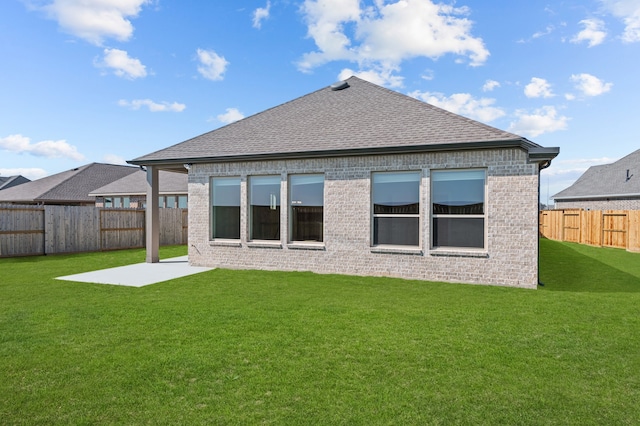 rear view of house with a patio and a yard