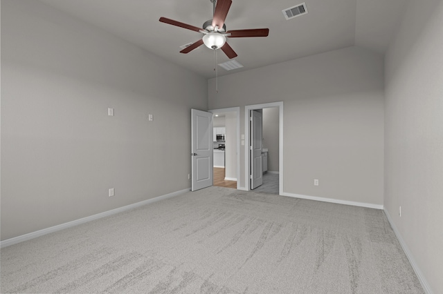 unfurnished bedroom with ceiling fan, connected bathroom, vaulted ceiling, and light carpet