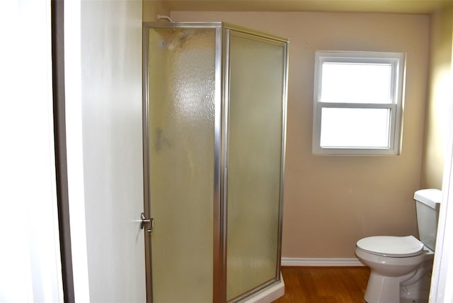 bathroom featuring hardwood / wood-style floors, an enclosed shower, and toilet