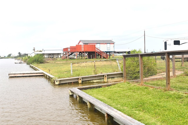 view of dock featuring a lawn and a water view