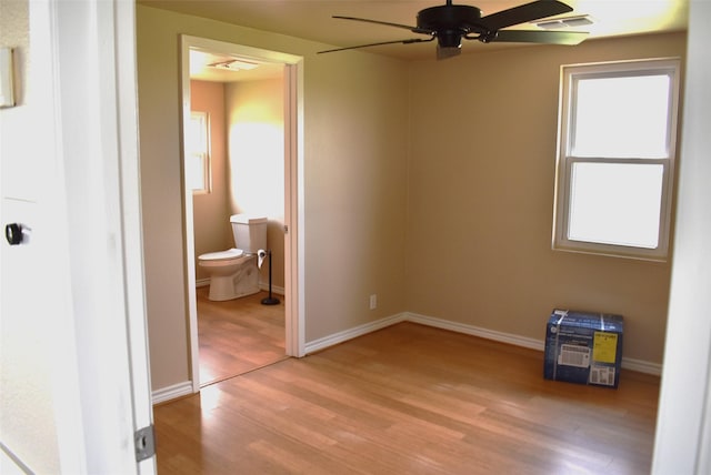 unfurnished bedroom with connected bathroom, ceiling fan, and light wood-type flooring