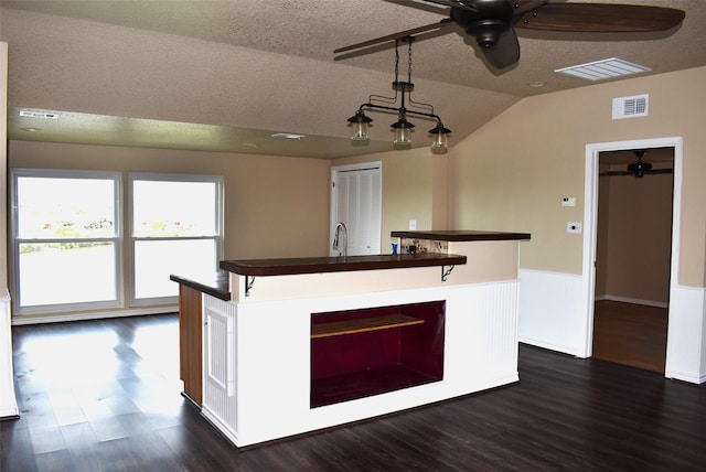 kitchen with vaulted ceiling, dark hardwood / wood-style flooring, ceiling fan, and a textured ceiling