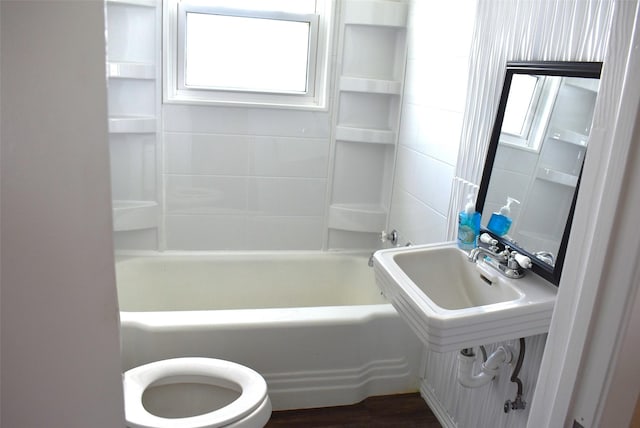 full bathroom with hardwood / wood-style flooring, toilet, bathing tub / shower combination, and sink