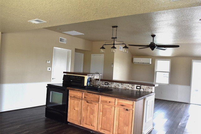 kitchen featuring black range with electric cooktop, an AC wall unit, sink, and a textured ceiling