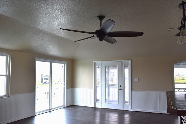 entryway with lofted ceiling, ceiling fan, dark wood-type flooring, and a textured ceiling