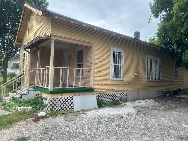 back of property featuring covered porch