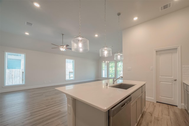 kitchen featuring light wood-type flooring, ceiling fan, sink, a center island with sink, and dishwasher