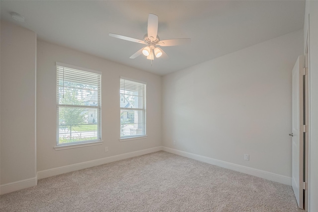 spare room featuring ceiling fan and light carpet