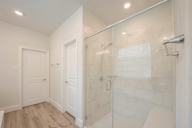 bathroom featuring wood-type flooring and an enclosed shower