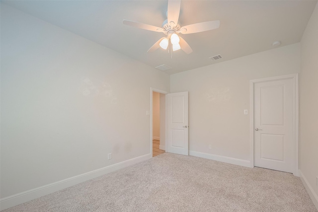 spare room featuring light carpet and ceiling fan