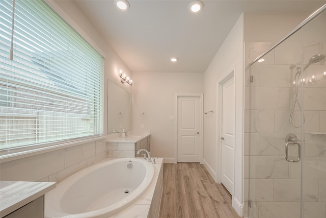 bathroom featuring hardwood / wood-style floors, vanity, and shower with separate bathtub