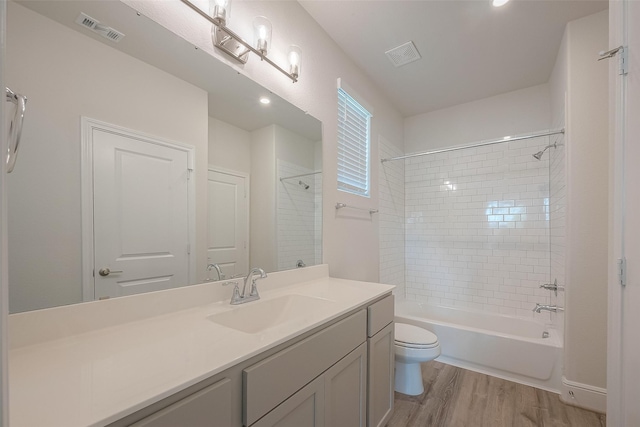 full bathroom featuring vanity, toilet, wood-type flooring, and tiled shower / bath