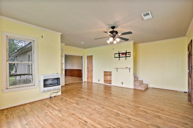 unfurnished living room with ceiling fan, heating unit, ornamental molding, and light wood-type flooring