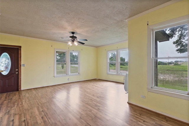 foyer entrance featuring ceiling fan, a textured ceiling, hardwood / wood-style flooring, and crown molding