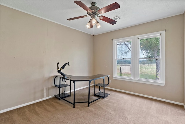 dining room with ceiling fan, a healthy amount of sunlight, light carpet, and a textured ceiling