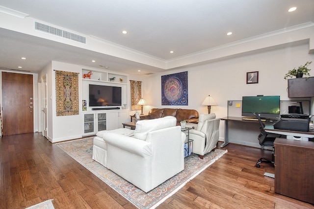 living room with hardwood / wood-style flooring, built in features, and crown molding