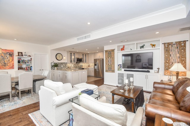 living room with wood-type flooring and crown molding