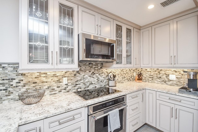 kitchen featuring light stone countertops, stainless steel appliances, and tasteful backsplash