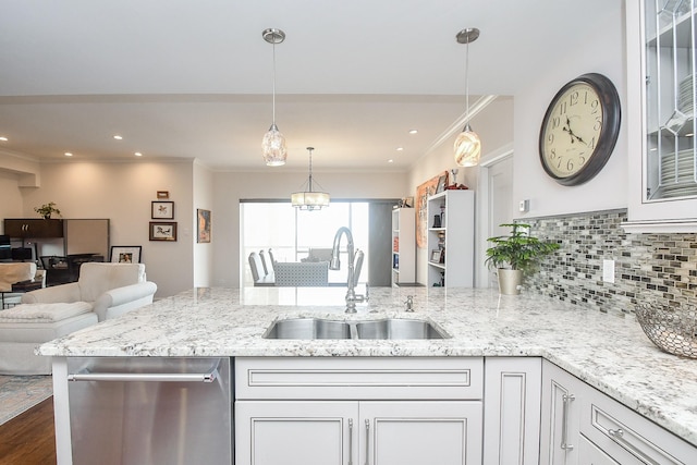 kitchen featuring hanging light fixtures, white cabinetry, sink, and stainless steel dishwasher