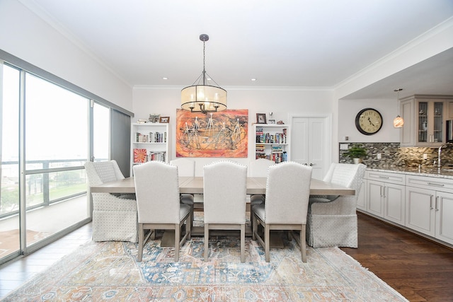 dining space with a notable chandelier, ornamental molding, and dark wood-type flooring