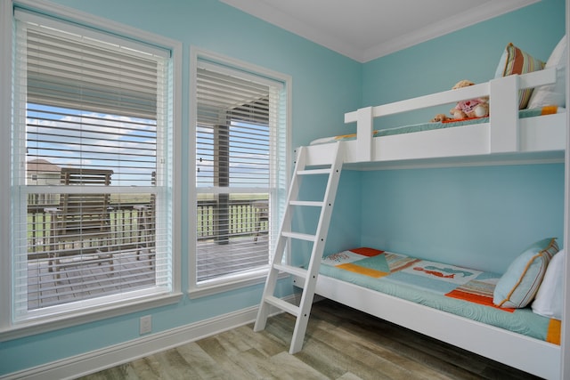 bedroom with ornamental molding and wood-type flooring