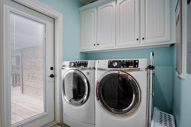 laundry area with cabinets and washing machine and clothes dryer