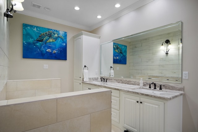 bathroom with a bathing tub, oversized vanity, double sink, and ornamental molding