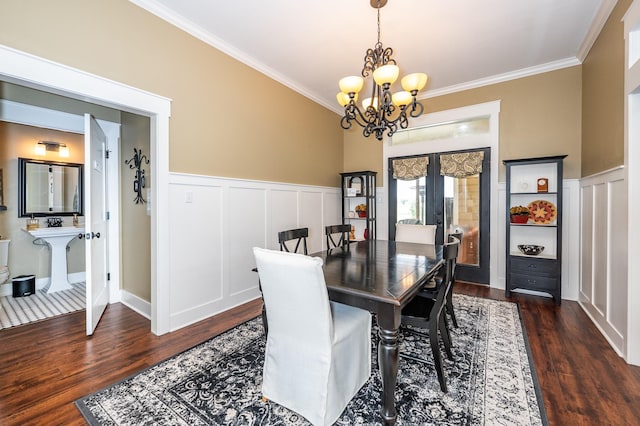 dining area featuring french doors, dark hardwood / wood-style flooring, an inviting chandelier, and ornamental molding