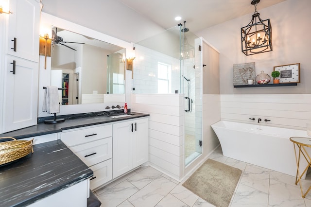 bathroom with ceiling fan with notable chandelier, vanity, and independent shower and bath