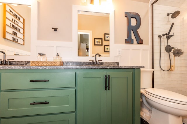 bathroom with a tile shower, vanity, and toilet